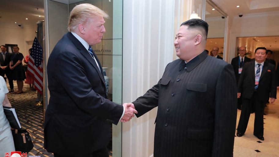Donald Trump shakes the hand of Kim Jong Un.
