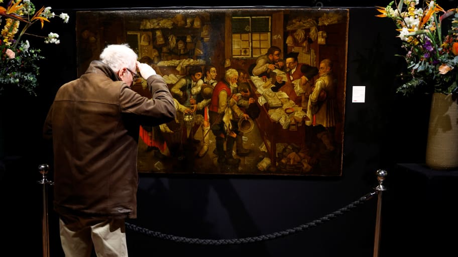A man looks at the painting, L'Avocat du village, now displayed in a gallery