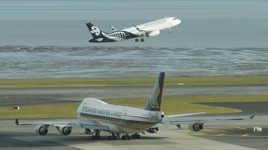 An Air New Zealand aircraft takes off from Auckland Airport alongside a Singapore Airlines cargo plane during fuel shortages in New Zealand, Sept. 20, 2017.