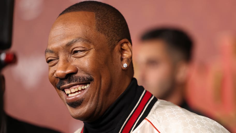 Eddie Murphy laughs while being photographed outside a movie premiere. 