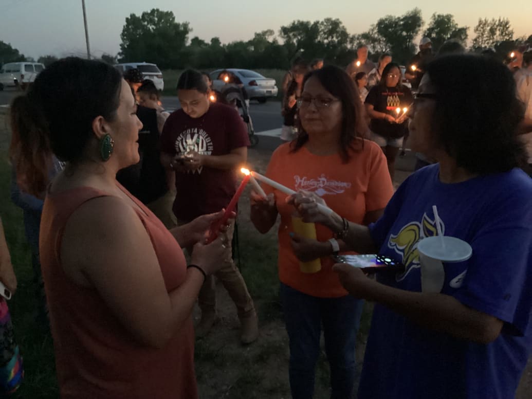 Three women light candles at the start of a vigil Monday night just east of Brookings, S.D., for Kyla Mercy Red Bear, whose body was found in a wooded area on Aug. 8, six days after she disappeared. 
