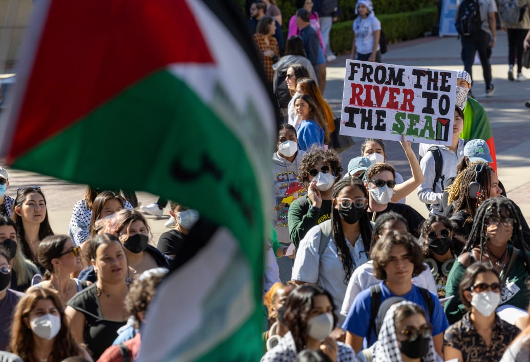 Photograph of a protest sign at a pro-Palestine rally reading "From The River to the Sea"