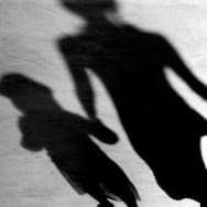 A photo of a shadow of a mother walking with a child.