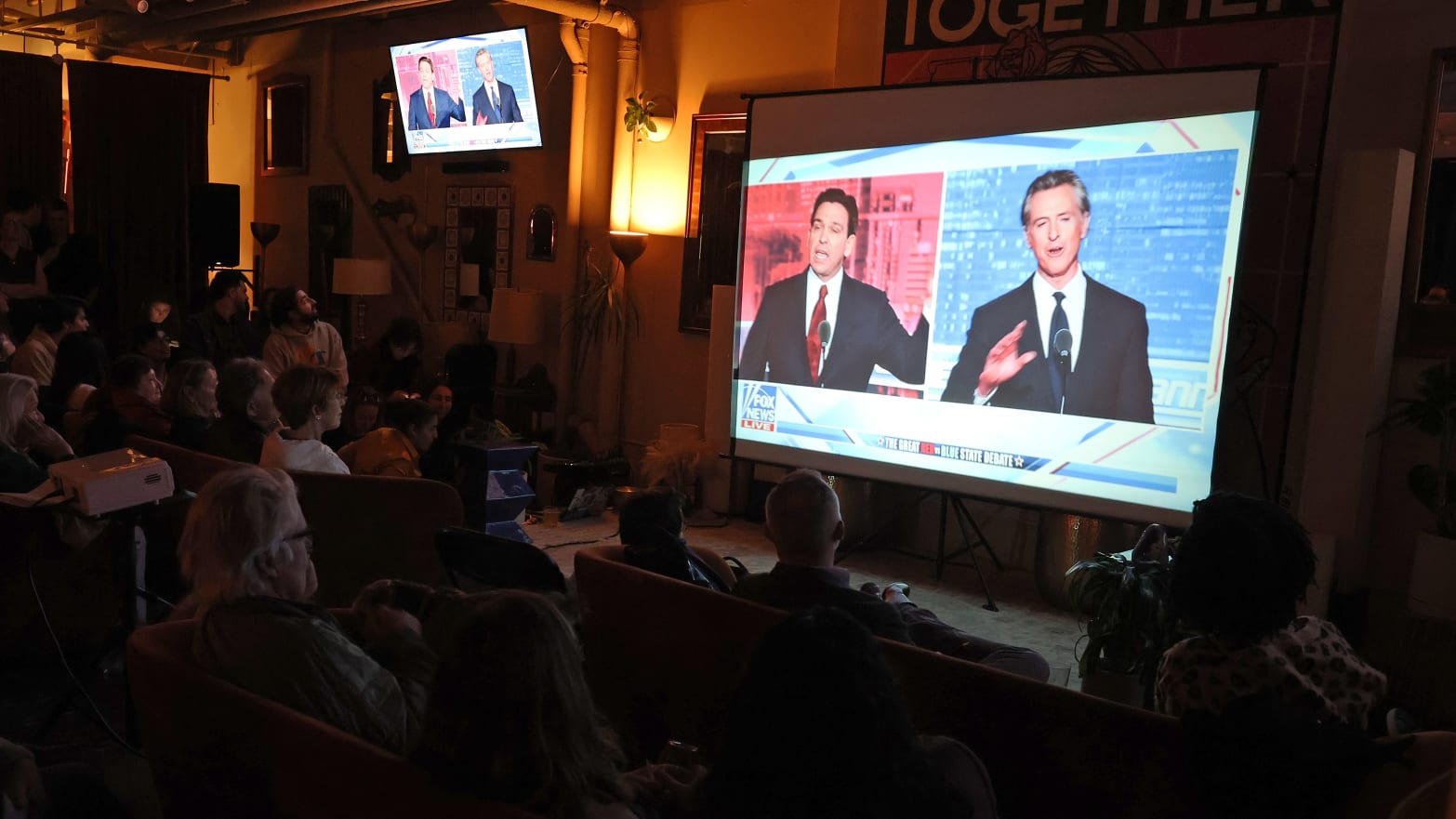 People watch a debate between California Gov. Gavin Newsom and Florida Gov. Ron DeSantis