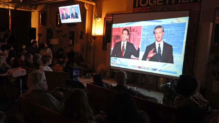 People watch a debate between California Gov. Gavin Newsom and Florida Gov. Ron DeSantis