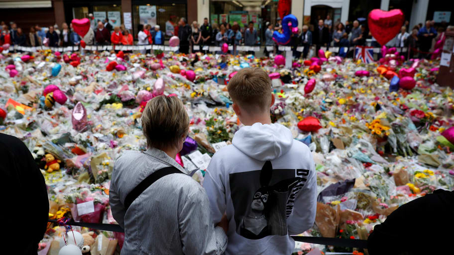 A boy wearing an Ariana Grande hoodie looks at flowers and tributes left for the victims of the attack on Manchester Arena in Manchester, Britain, May 29, 2017. 