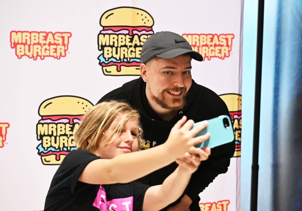 MrBeast poses with a fan at the opening of the first physical MrBeast Burger restaurant at the American Dream on September 4, 2022  