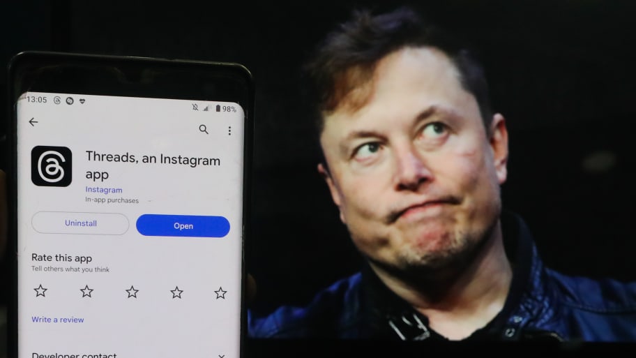 A man shows the newly introduced ''Threads'' app with an Elon Musk background. Meta CEO Mark Zuckerberg, who launched Threads, trolled Musk in his first tweet since 2012 with a meme referencing the new platform.