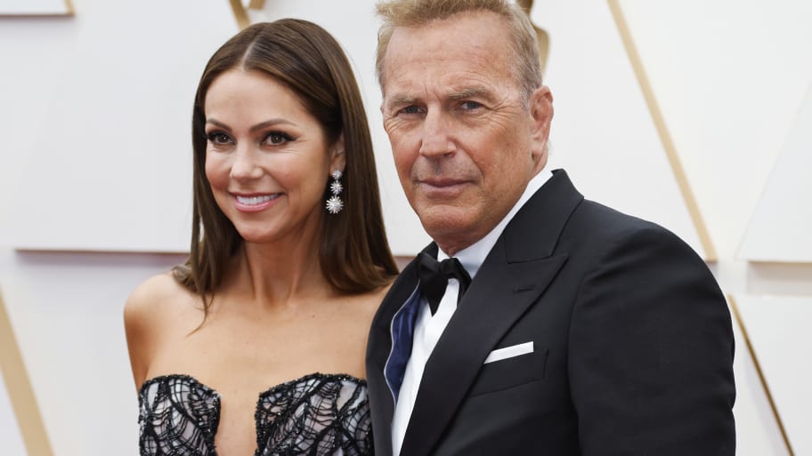 Kevin Costner and wife Christine Baumgartner pose on the red carpet during the Oscars arrivals at the 94th Academy Awards.