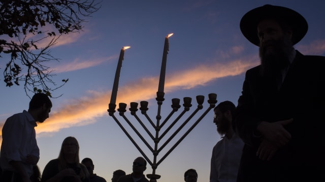 lighting a menorah on the first day of Hanukkah