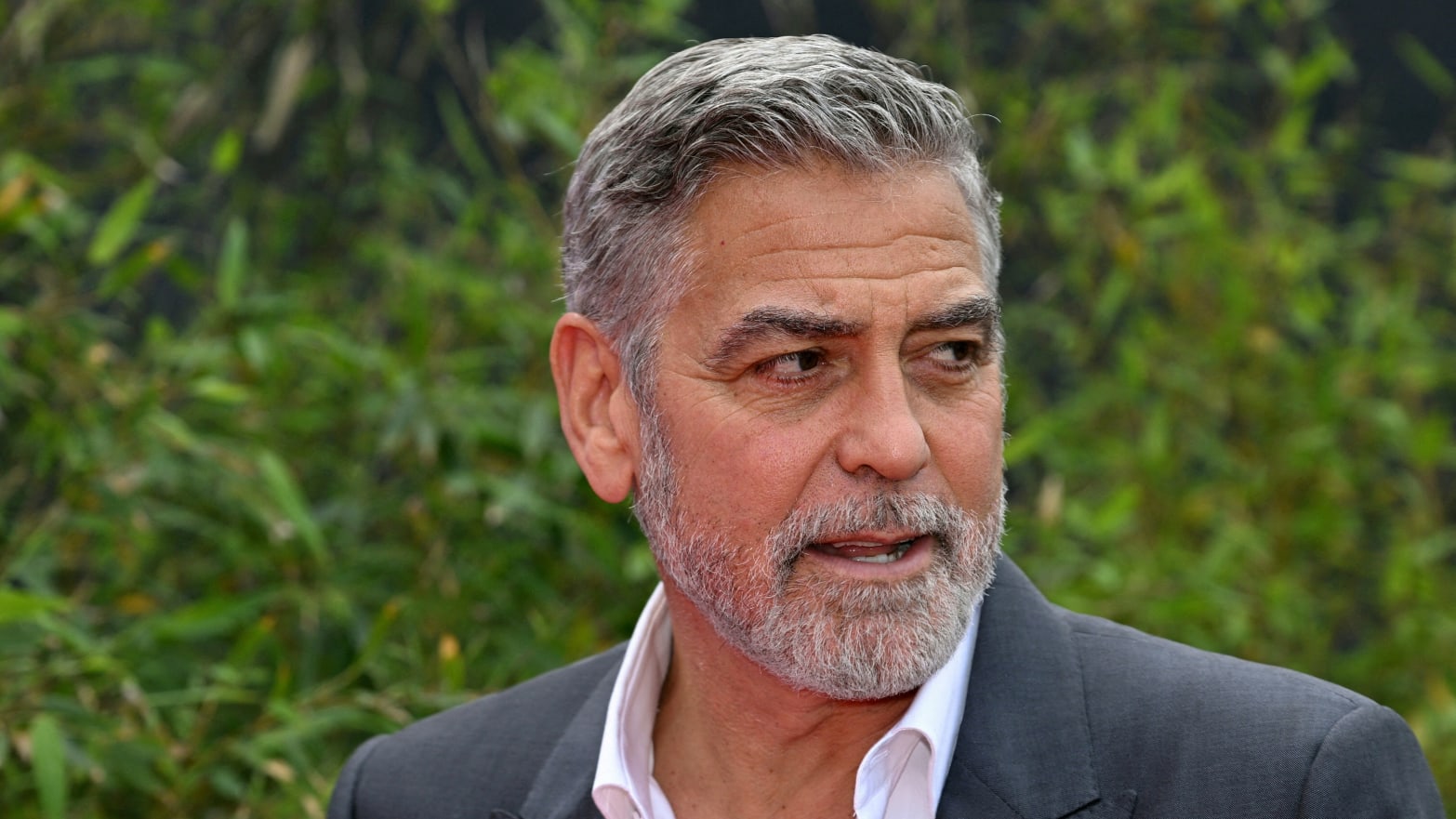 George Clooney stares to his left while at an outdoors event.