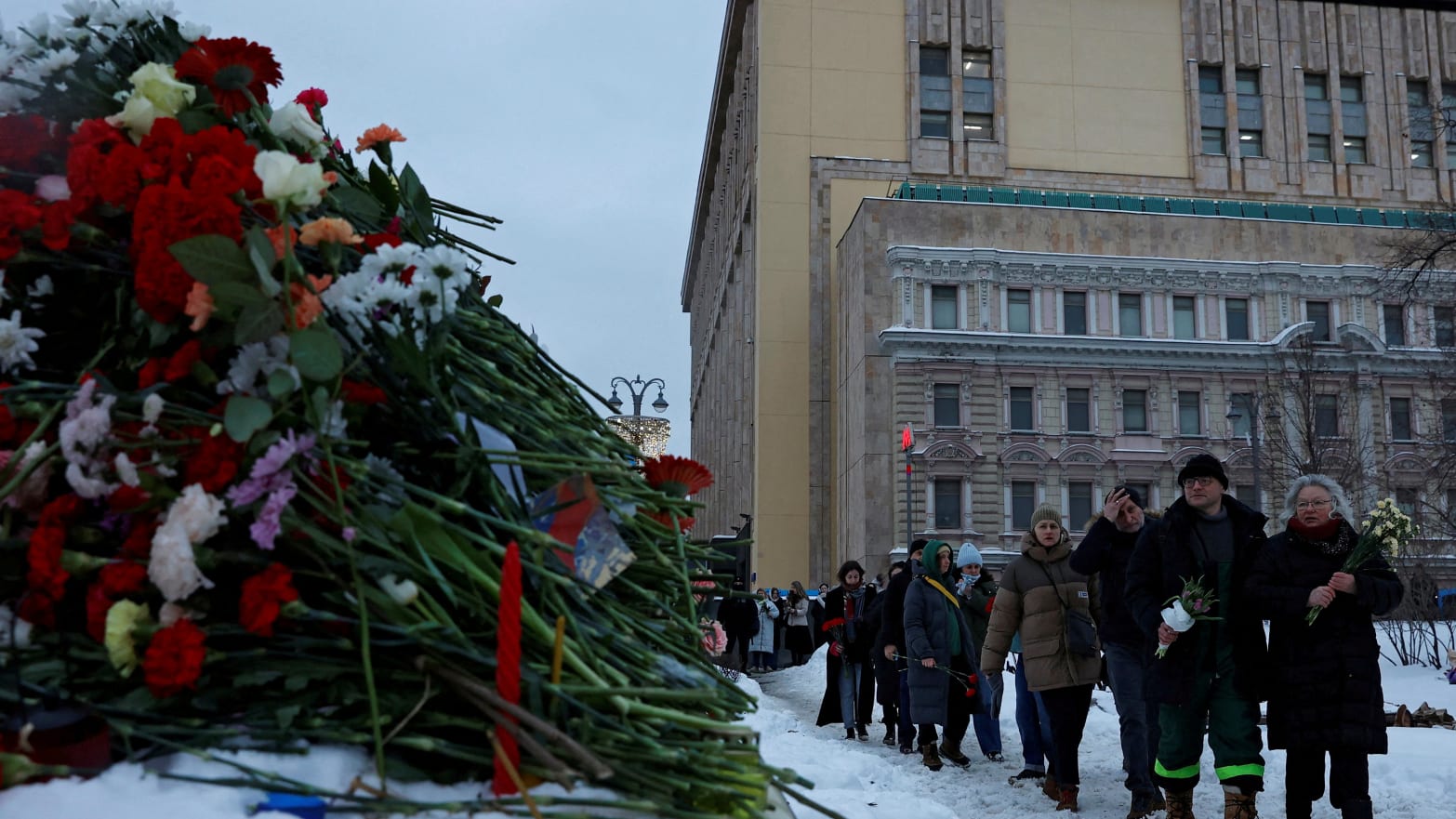 People walk to lay flowers at the Solovetsky Stone monument to the victims of political repressions to honour the memory of Russian opposition leader Alexei Navalny in Moscow, Russia February 17, 2024. 