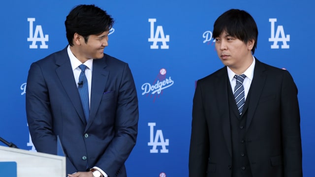Shohei Ohtani speaks with his interpreter Ippei Mizuhara prior to being introduced by the Los Angeles Dodgers at Dodger Stadium on December 14, 2023 in Los Angeles, California.