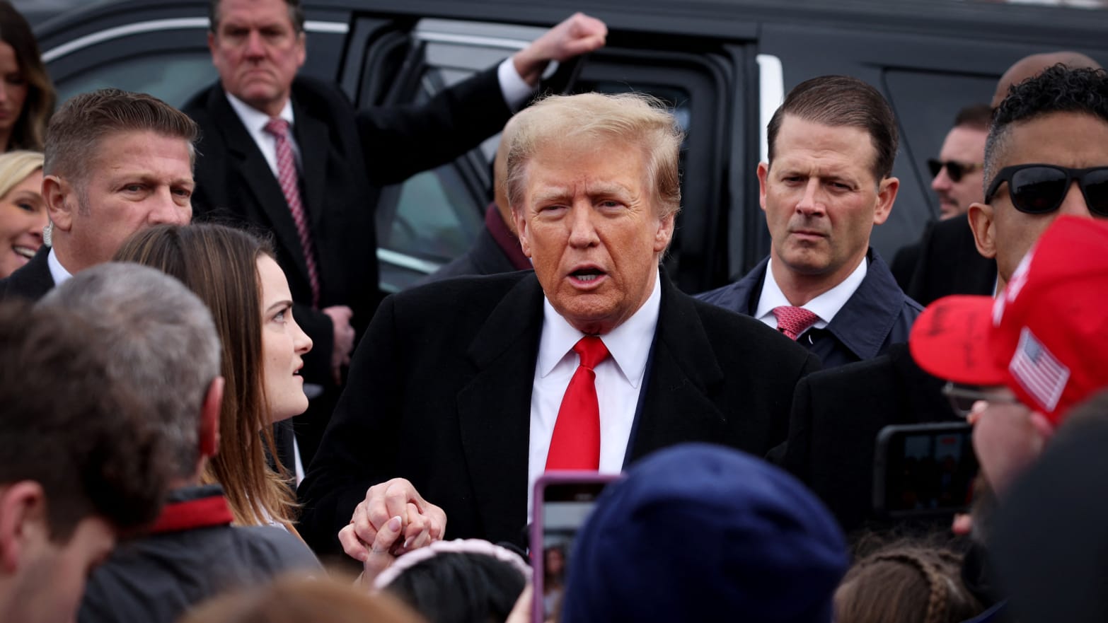 Former President Donald Trump greets supporters as makes a visit to a polling station on election day in the New Hampshire presidential primar