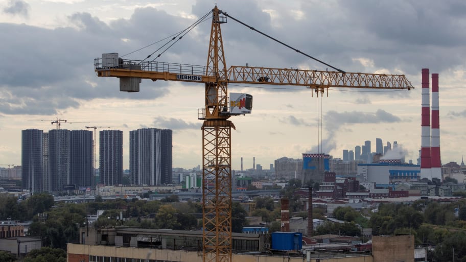 A view of a construction crane with city skyline in the background in Moscow.