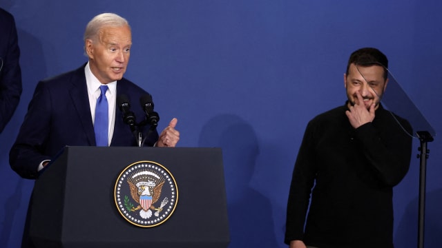 U.S. President Joe Biden speaks at a Ukraine Compact meeting, as Ukraine's President Volodymyr Zelensky stands next to him.