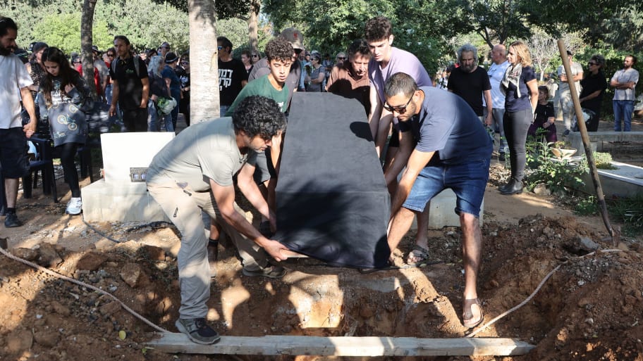 Mourners lay the coffin of Tom Godo, killed during the attack by Palestinian Hamas militants on the Kibbutz Kisuffim