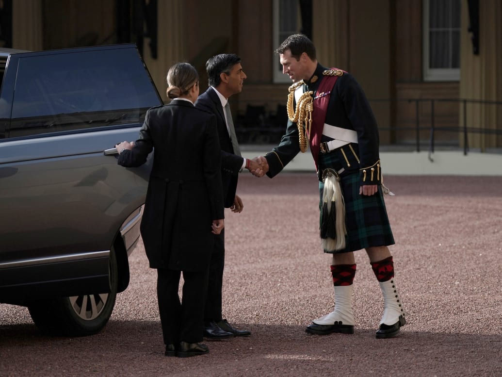 Rishi Sunak is greeted by King Charles III's equerry, Lieutenant Colonel Johnny Thompson, as he arrives at Buckingham Palace, London, for an audience with Charles, October 25, 2022.