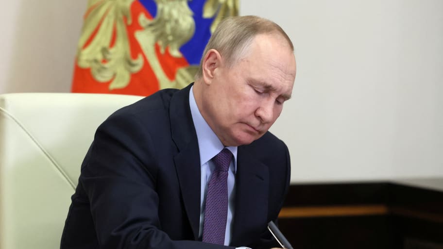 Russian President Vladimir Putin takes notes