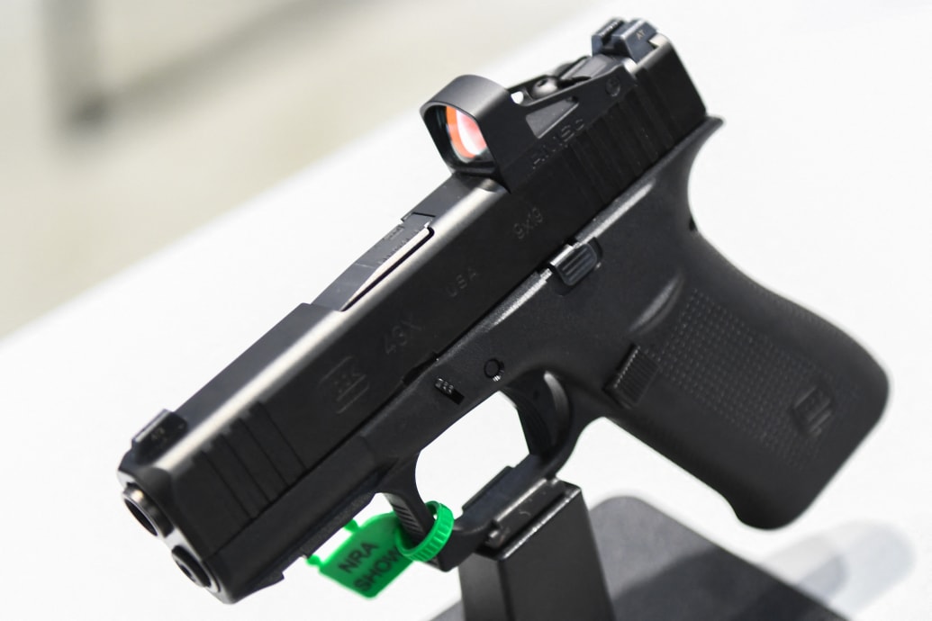 A photo of a Glock handun on a stand at a gun show.