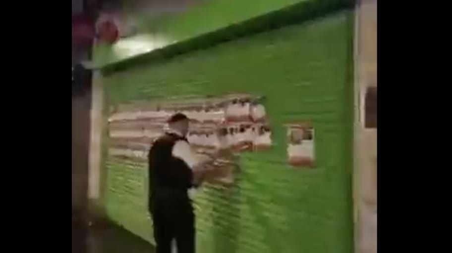 Metropolitan Police officers tear down posters of Hamas hostages in London.