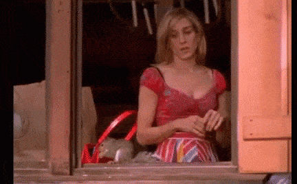 Gif: Carrie Bradshaw sees squirrel outside the window and screams and runs away.