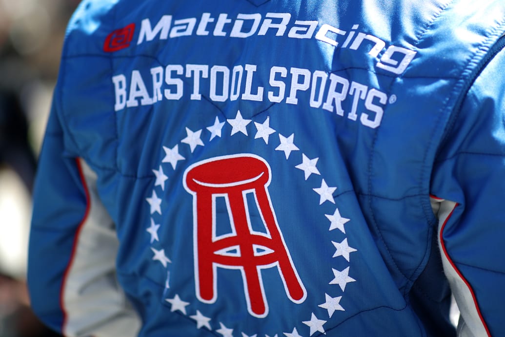 The Barstool Sports logo appears on the jacket of a NASCAR driver.