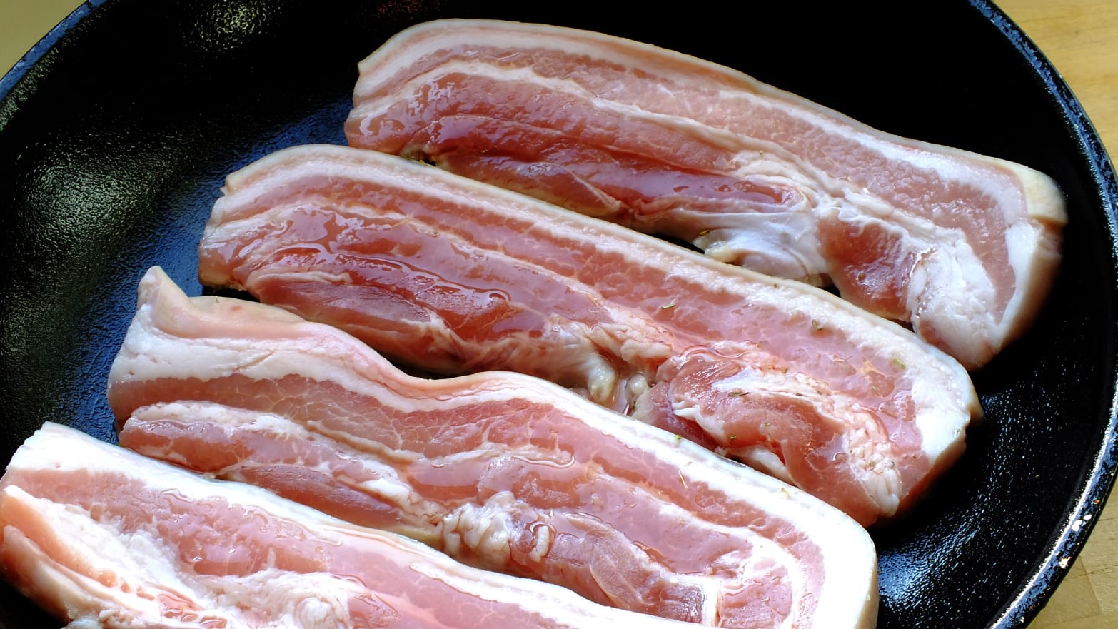 A panful of uncooked bacon.