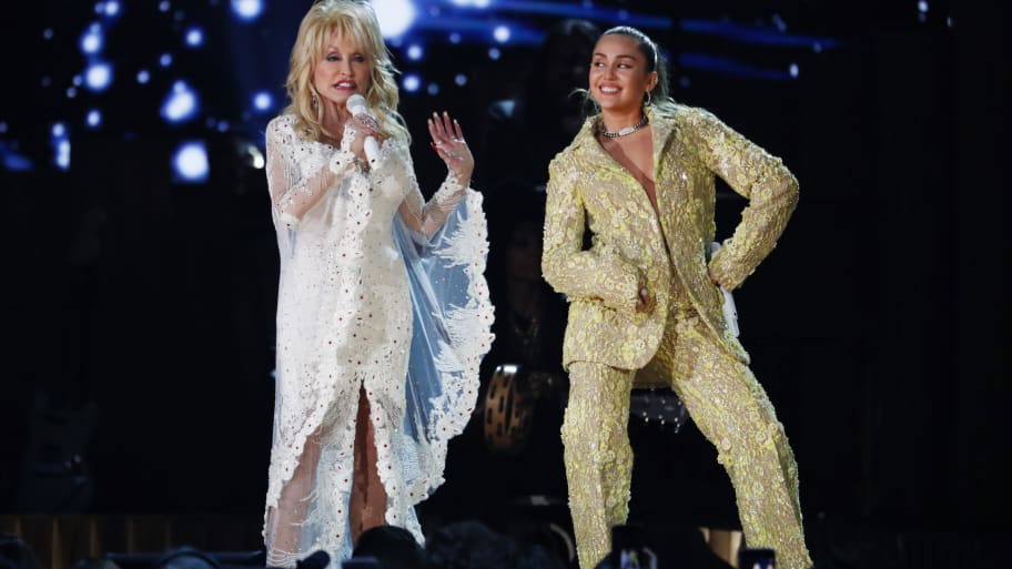 Dolly Parton (left) and Miley Cyrus (right) perform on stage.