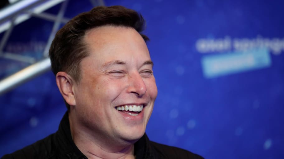 SpaceX owner and Tesla CEO Elon Musk laughs after arriving on the red carpet for the Axel Springer award, in Berlin, Germany, December 1, 2020. 