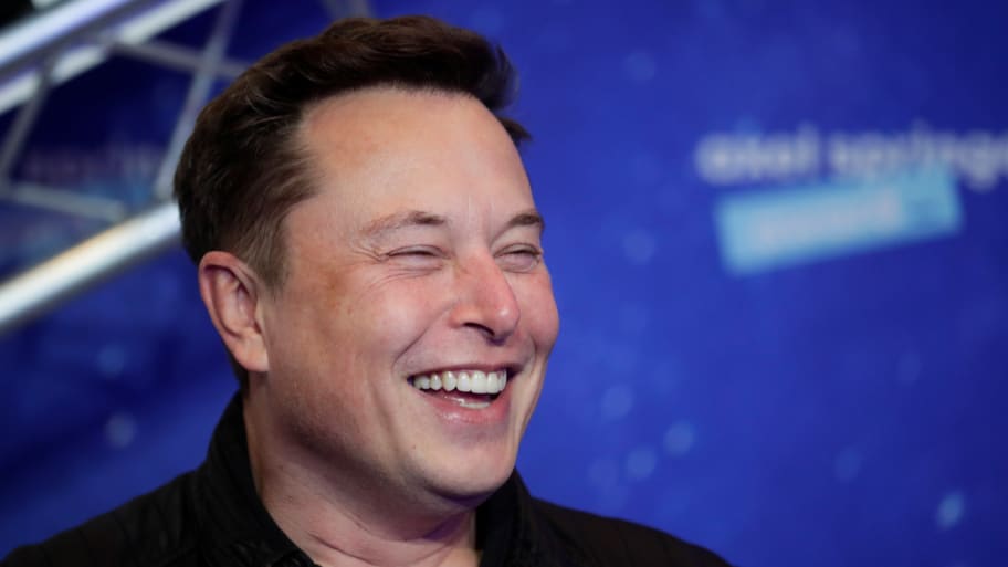 SpaceX owner and Tesla CEO Elon Musk laughs after arriving on the red carpet for the Axel Springer award, in Berlin, Germany, December 1, 2020. 