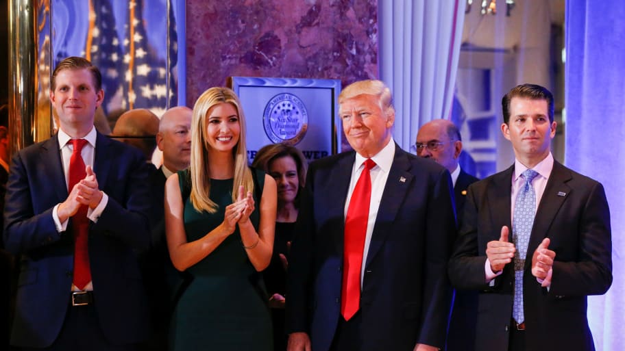 U.S. President-elect Donald Trump (C) smiles as he is applauded by his son Eric Trump (L) daughter Ivanka and son Donald Trump Jr. (R) ahead of a press conference in Trump Tower, Manhattan.