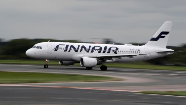 A white Finnair plane takes off from a runway.