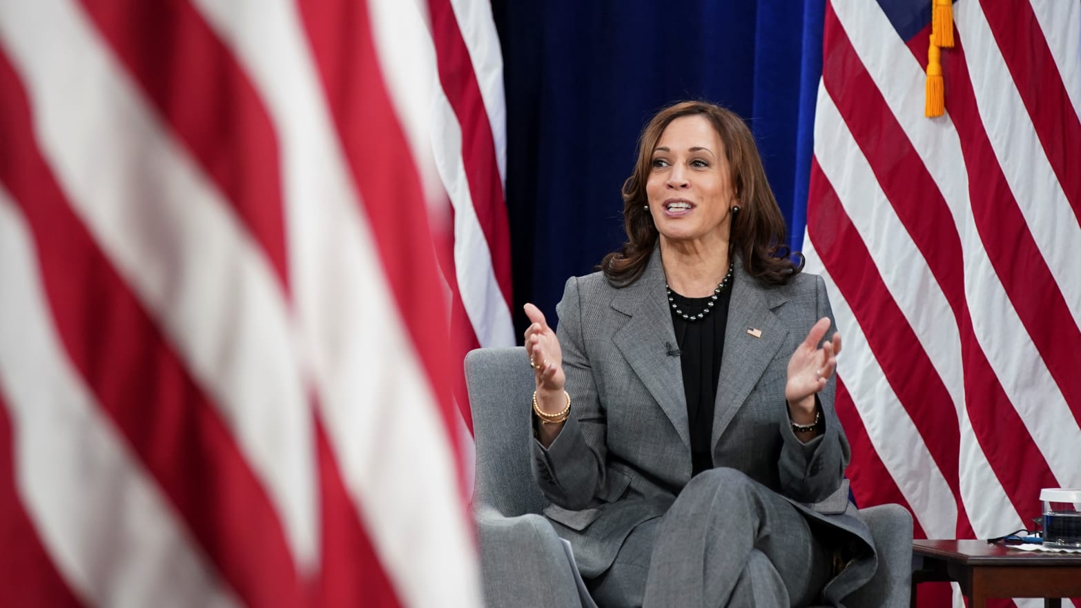 Kamala Harris clapping surrounded by US flags