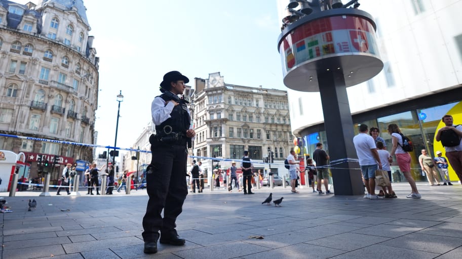 Police officers at the scene in Leicester Square, London, as a man has been arrested after an 11-year-old girl and 34-year-old woman were stabbed. 