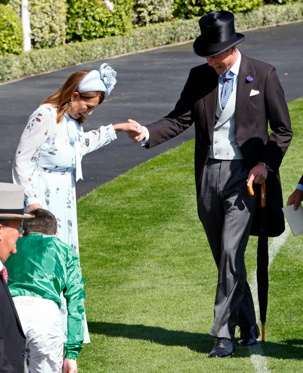 Prince William, Prince of Wales assists Carole Middleton as she gets the heel of her shoe stuck in the grass on day two of Royal Ascot 2024 at Ascot Racecourse on June 19, 2024 in Ascot, England.
