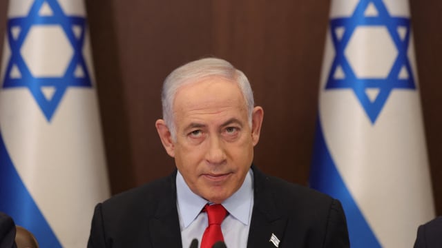 Israeli Prime Minister Benjamin Netanyahu before Israeli flags