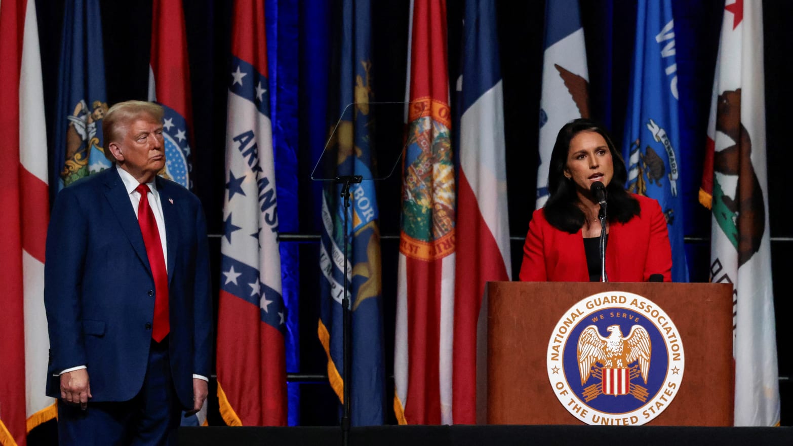 Former president Donald Trump listens as Tulsi Gabbard speaks at a meeting of the National Guard Association in Detroit, Michigan on August 26, 2024