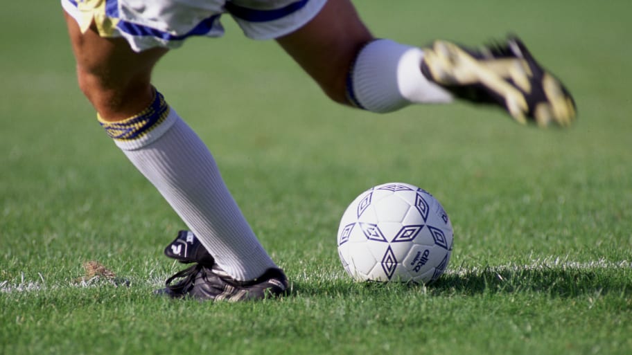 A player kicks a soccer ball.