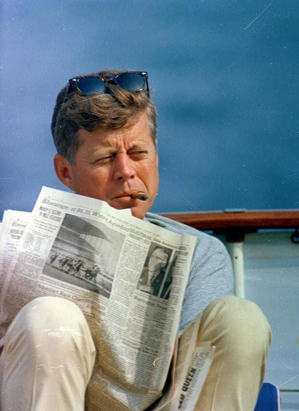 President John F. Kennedy smokes a cigar on a boat.