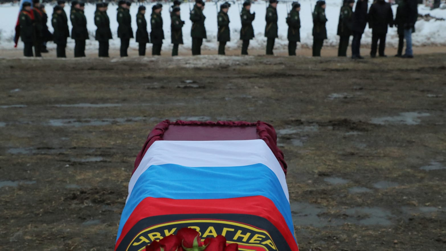 The coffin of Wagner mercenary Dmitry Menshikov, killed during the war in Ukraine, is covered with flags during his funeral in the Alley of Heroes at a cemetery in St. Petersburg, Russia, Dec. 24, 2022.
