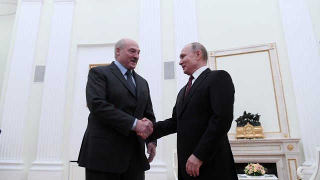 Vladimir Putin shakes hands with Alexander Lukashenko in Moscow.