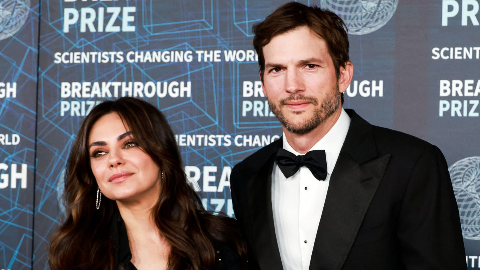 Mila Kunis and Ashton Kutcher pose at the Academy Museum of Motion Pictures in Los Angeles.