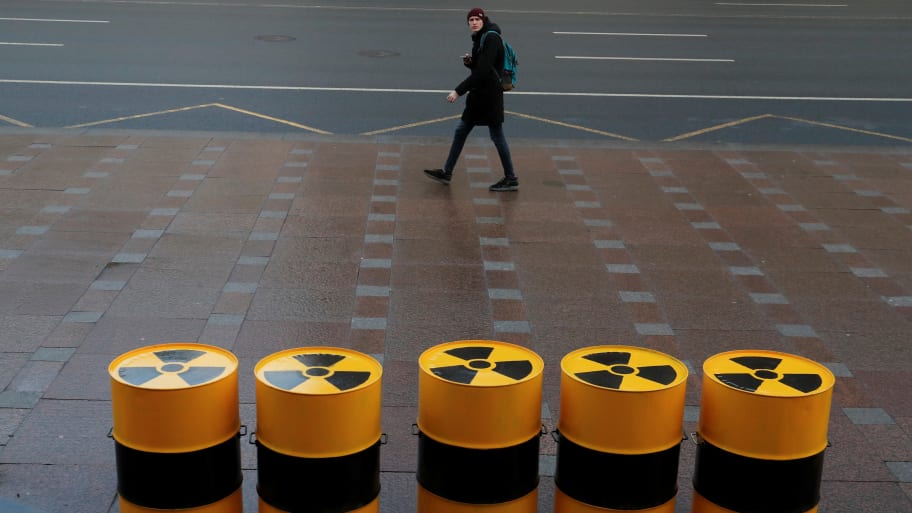 A pedestrian walks past barrels during a picket held by Greenpeace activists to protest against importing radioactive waste into Russia for storage in St. Petersburg, Russia.