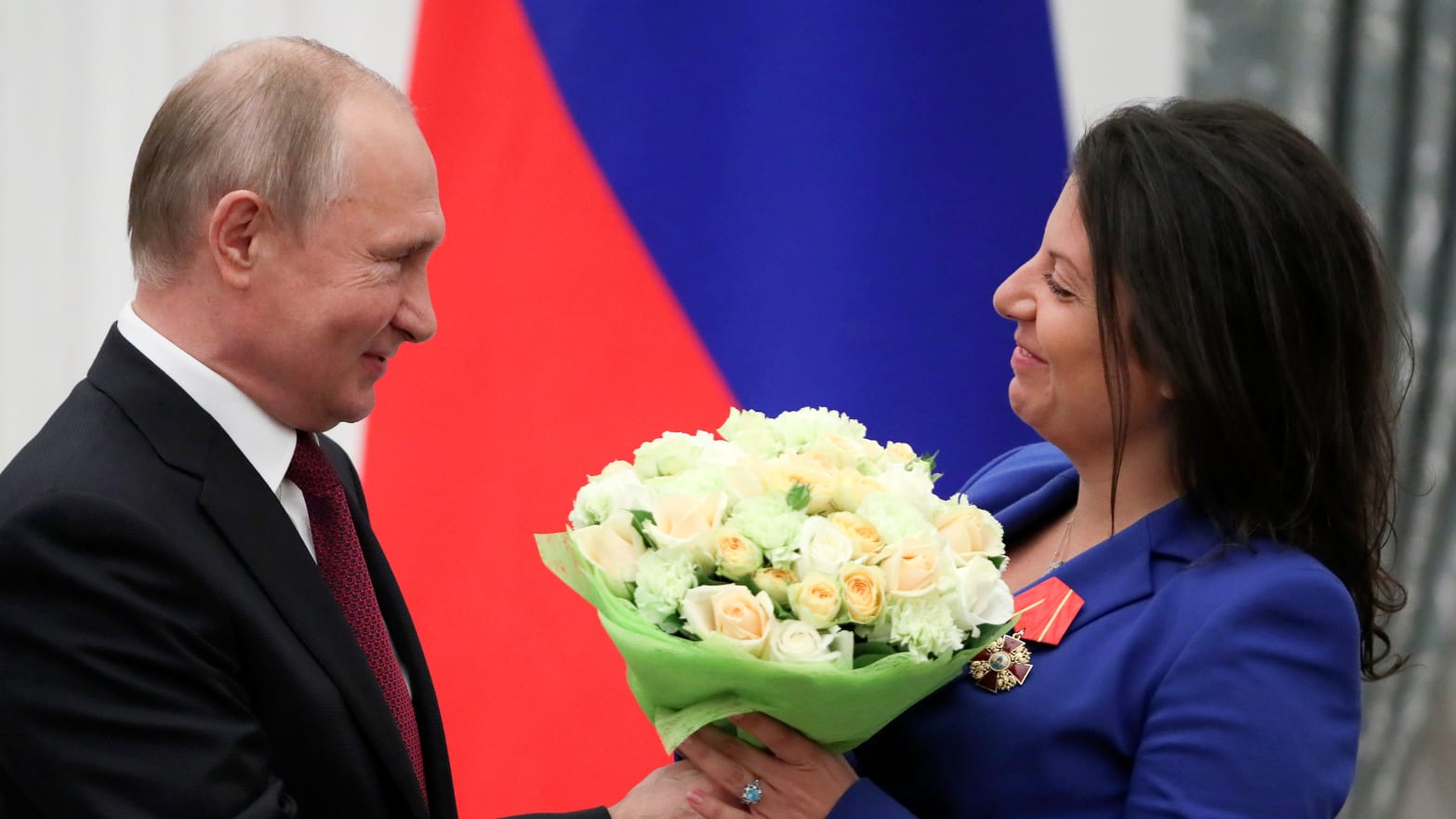 image: Margarita Simonyan receiving a bouquet of flowers from Vladimir Putin