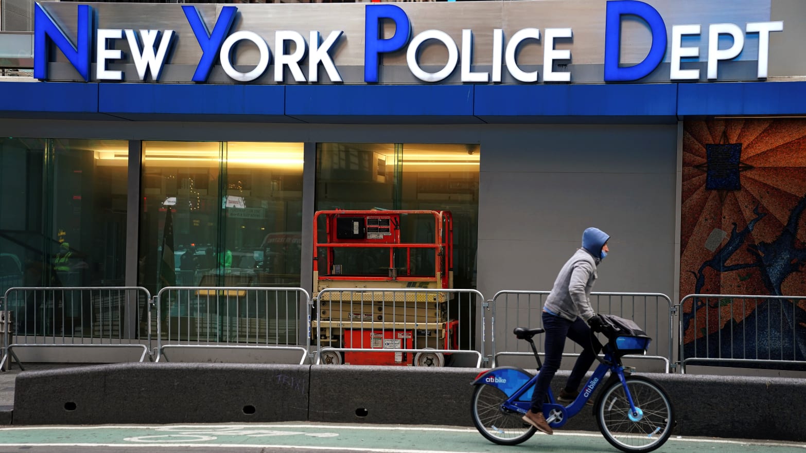 A cyclist rides past a New York Police Department (NYPD) station in Times Square