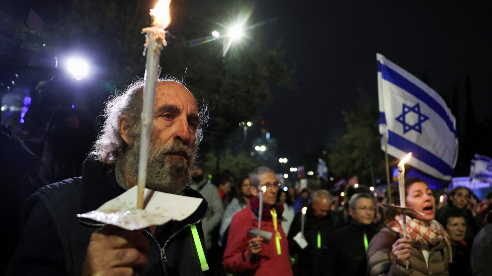 Israelis, carrying candles and Israel flags, attend a rally for the return of hostages.