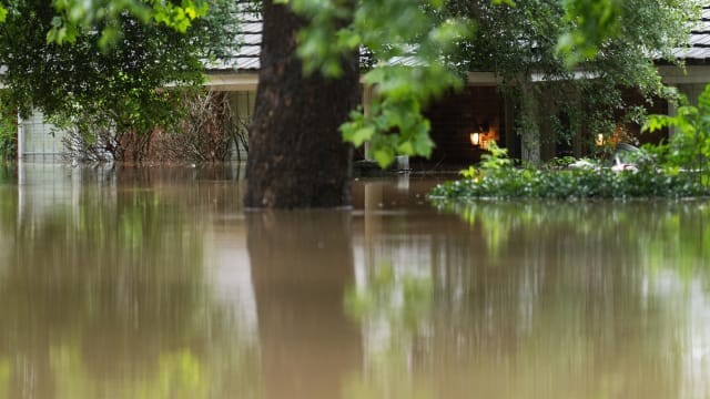 A home in River Plantation is seen with its lights on in flood water.