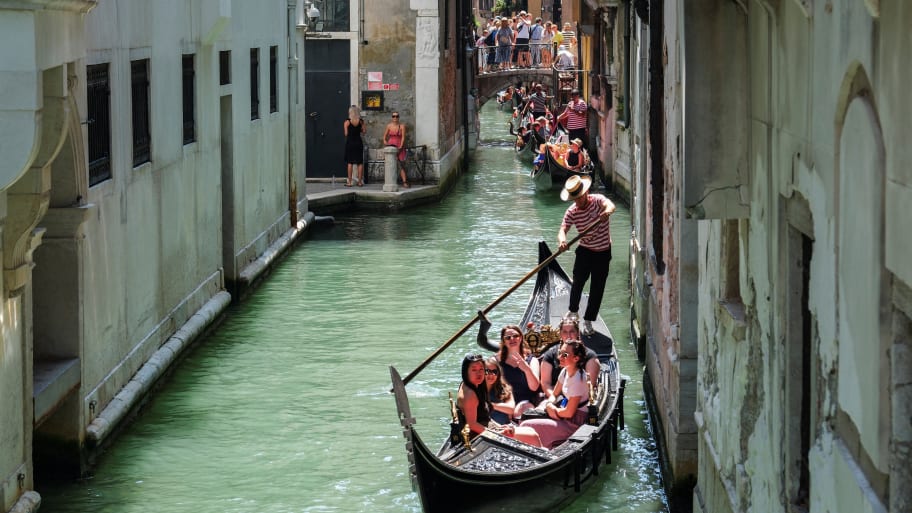Gondoliers row their gondolas through the Venice Canal as the city prepares for the Redentore Festival celebrations in Venice, Italy
