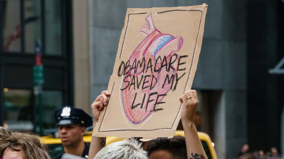 Participants hold signs while protesting the repeal and replacement of the Affordable Care Act. 